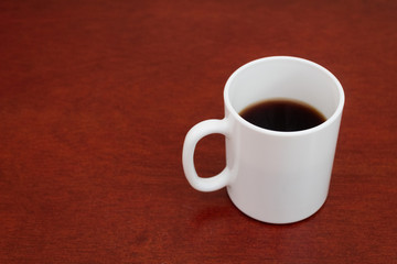 Taza blanca de café en mesa de madera