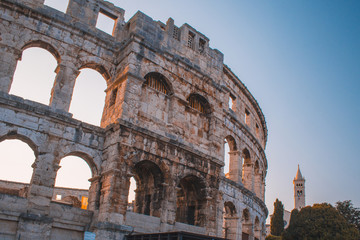 Fototapeta premium Ancient Roman Amphitheater in Pula, Istrian Peninsula in Croatia. Empty street during early morning.