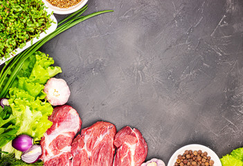 fresh raw beef marble meat with vegetables and sprouts of flax microgrid on a dark stone background. the concept of a healthy lifestyle