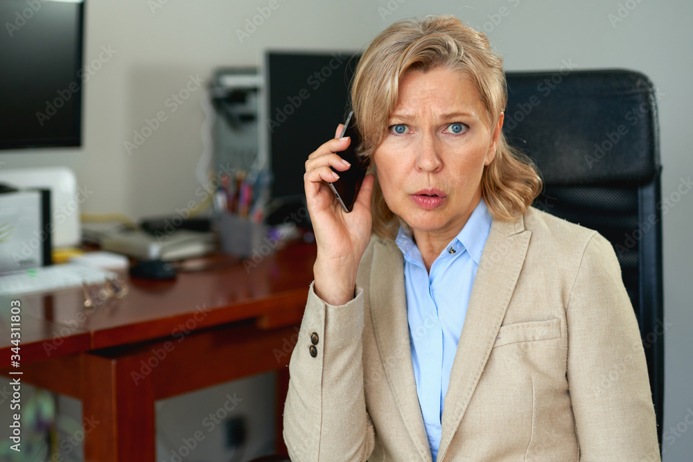 Wall mural portrait of mature female boss working in office.