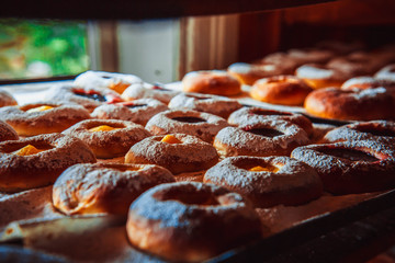 Round donuts sprinkled with white powder, packed in a row on the window