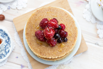 Raw vegan pancakes on a wooden plate with raspberries on top. Healthy eating lifestyle.