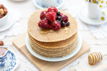 Raw vegan pancakes on a wooden plate with raspberries on top. Healthy eating lifestyle.