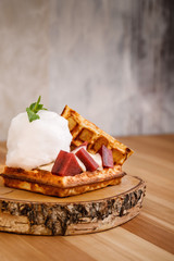 Presentable plating of Belgian waffle topped cotton candy and sweets. Food photography concept for magazine or online delivery menu.