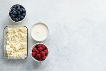  Curd and cheese dumplings served with berries and sour cream on a ceramic white plate. Traditional Ukrainian or Russian lazy dumplings (vareniki). Healthy Breakfast, top view.