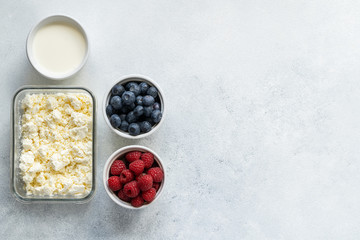 Curd and cheese dumplings served with berries and sour cream on a ceramic white plate. Traditional Ukrainian or Russian lazy dumplings (vareniki). Healthy Breakfast, top view.