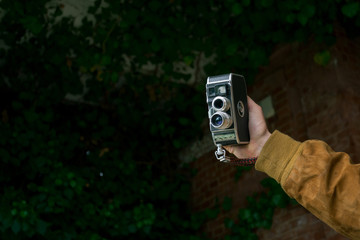 a hand holds a vintage camera
