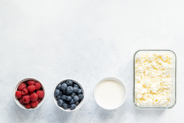  Curd and cheese dumplings served with berries and sour cream on a ceramic white plate. Traditional Ukrainian or Russian lazy dumplings (vareniki). Healthy Breakfast, top view.