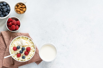  Curd and cheese dumplings served with berries and sour cream on a ceramic white plate. Traditional Ukrainian or Russian lazy dumplings (vareniki). Healthy Breakfast, top view.