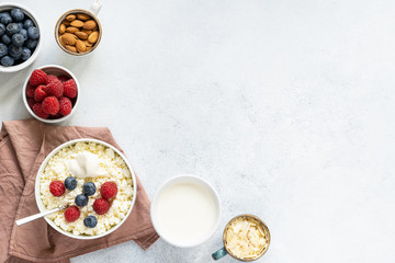  Curd and cheese dumplings served with berries and sour cream on a ceramic white plate. Traditional Ukrainian or Russian lazy dumplings (vareniki). Healthy Breakfast, top view.