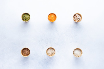 Dry bio cereals in craft bio cups made of paper on a gray background. Concept of healthy food with home delivery. Top view, Copy space.