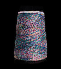 Yarn for knitting on bobbins, bobbin yarn on a black background. Knitting, machine knitting.