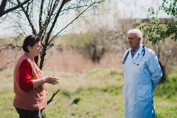 Senior woman listening as her doctor explains the details of therapy during a home call visit.