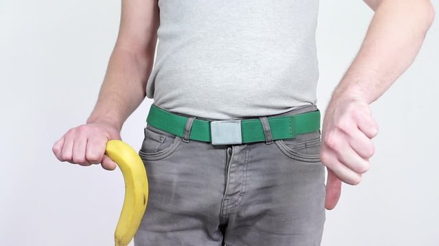 A man demonstrates the big banana raising it up and down.