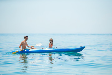 Fototapeta na wymiar Sporty attractive family kayaking on sea together