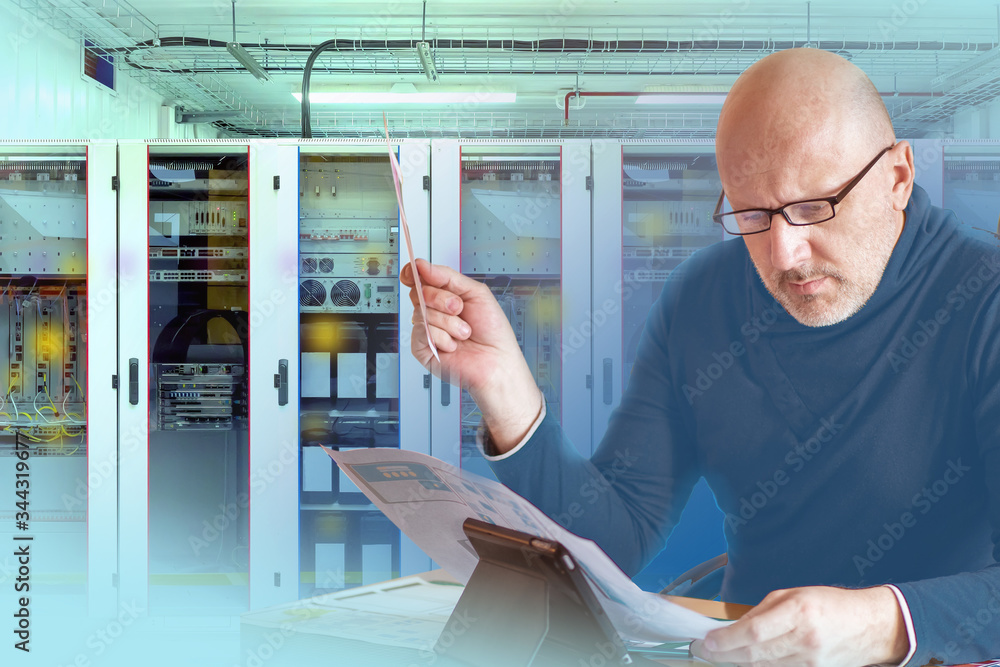 Poster engineer on the background of the switchboard. a man studies the circuit of the switchboard. the wor