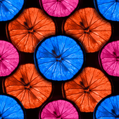 seamless pattern of slices of multicolor citrus fruit with backlight isolated on black background, can be tiled