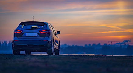 Fototapeta na wymiar car at sunset, on city background.