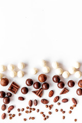 Sweets background with chocolate pralines on white desk top-down frame copy space