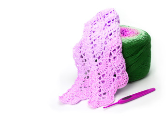 Crochet, the process of knitting a scarf. Threads and crochet tools on a white background.