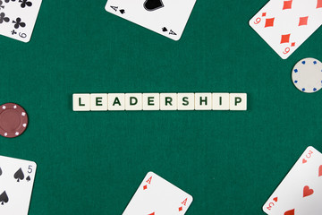 Leadership concept with poker cards and chips on a green background