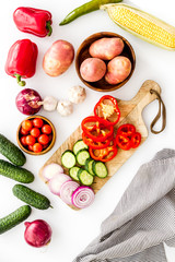 Fresh vegetables still life. Potato, cucumber, beet carrot, greenery on white background top-down