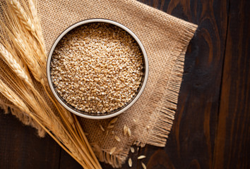 Bowl of Raw Steel Cut Oats on Burlap Fabric with Copy Space