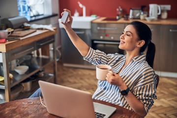 Pretty lady drinking warm beverage at home