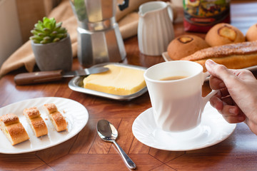 Breakfast with white crockery, coffee, cheese rolls, bread and milk
