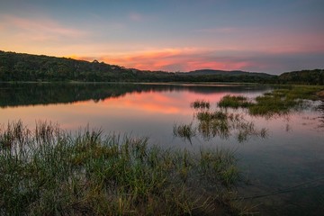 Fototapeta na wymiar reveres sunset on the lake pink sky