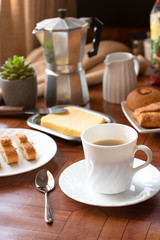 Breakfast with white crockery, coffee, cheese rolls, bread and milk