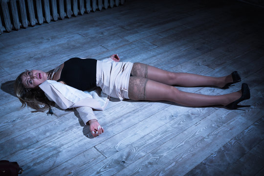 Crime scene with strangled pretty business woman lying on the floor