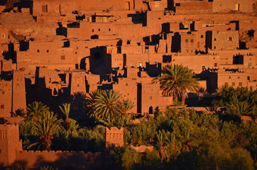 Budynki w mieście Warzazat w Maroko oświetlone promieniami wschodzącego Słońca 