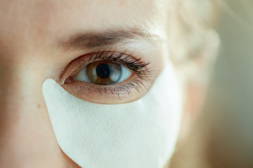 Closeup on woman using white cotton eye patches