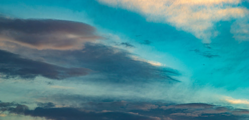 Clouds and roofs of houses in the evening sky
