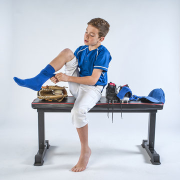 Boy baseball player dressing for a game