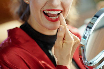 trendy woman looking in mirror and checking teeth