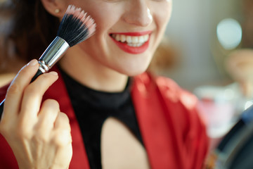 modern woman in house in sunny day using cosmetic brush
