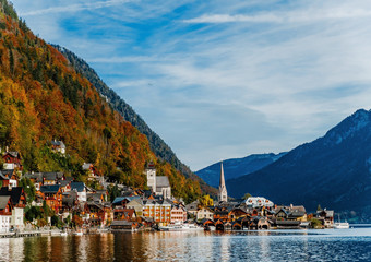 Scenic panoramic view of the famous mountain village in the Austrian Alps. Autumn Landscape. Hallstatt, Austria. Blue lake, sky and mountains. Beautiful and cozy town. Postcard concept.