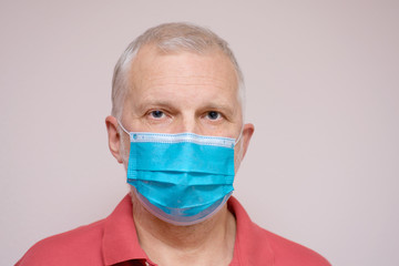 Elderly man in a disposable protective mask. Elderly people at high risk of coronavirus concept