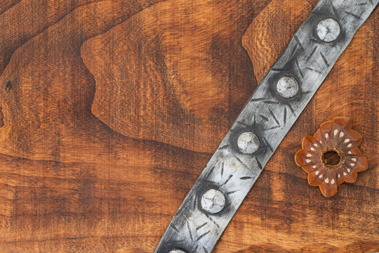 an amphora and medieval punche belt on a rough wooden texture grunge sea washed weathered wood and colorful sea urchin shells top view, filtered image with some space for typing.