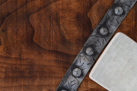 an amphora and medieval punche belt on a rough wooden texture grunge sea washed weathered wood and colorful sea urchin shells top view, filtered image with some space for typing.