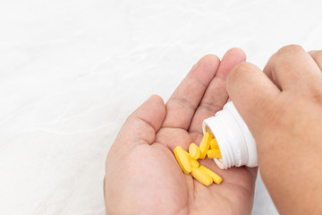 Hands with pills in the box with white background