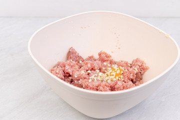 Raw minced meat with smashed eggs and chopped onion mixture for meatballs