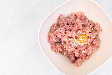 Raw minced meat with smashed eggs and chopped onion mixture for meatballs