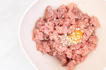 Raw minced meat with smashed eggs and chopped onion mixture for meatballs
