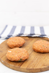 Raw minced meat meatballs on the wooden board ready for frying with copy space above