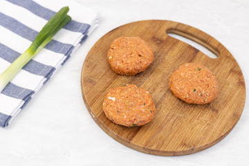 Raw minced meat meatballs on the wooden board ready for frying