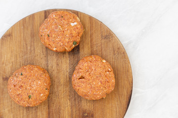 Raw minced meat meatballs on the wooden board ready for frying