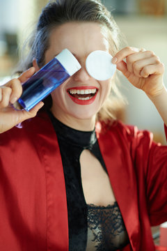 happy housewife showing makeup remover with cotton pads